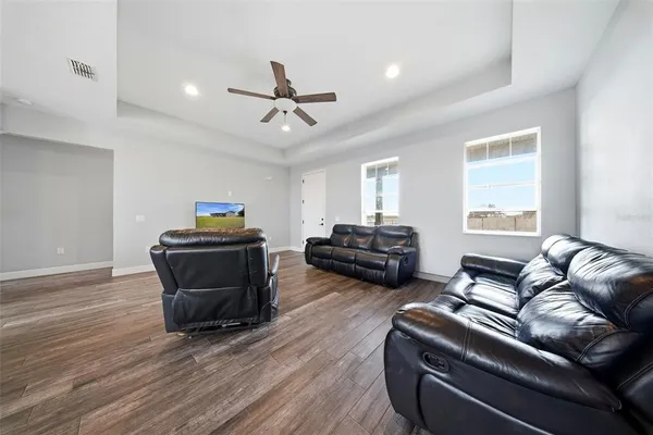 a living room with furniture a ceiling fan and a window
