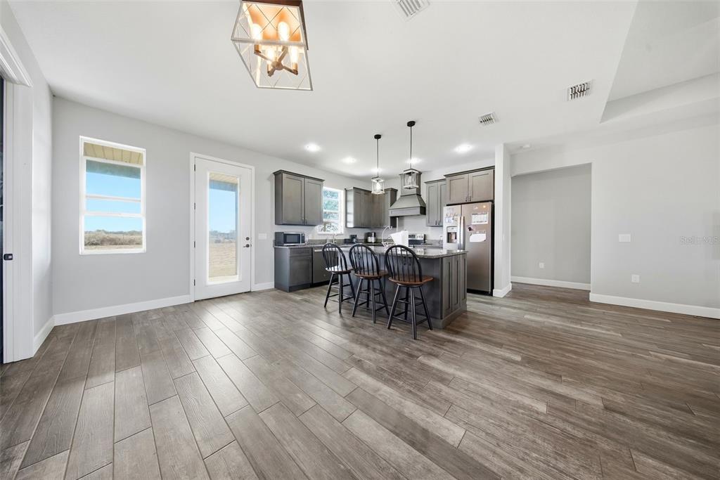 3090 80 Foot Road Bartow, FL 33830 - Photo 8 of 48 a view of a dining room and livingroom with furniture wooden floor a chandelier
