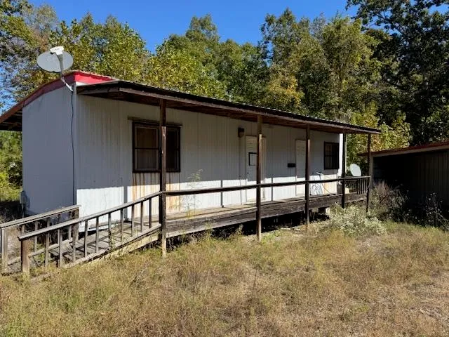 a view of backyard with large trees and wooden fence