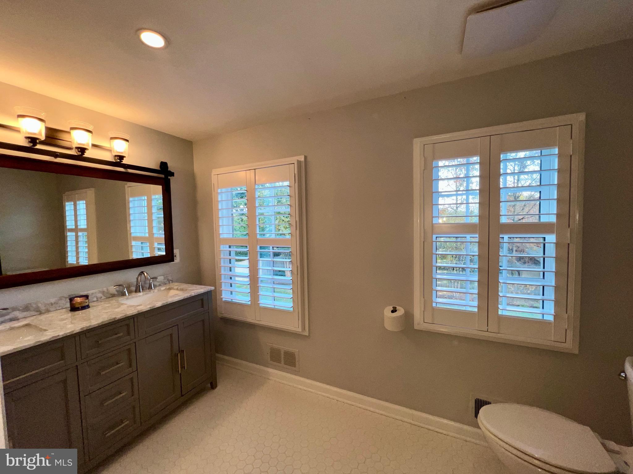 909 St Stephens Road Alexandria, VA 22304 - Photo 18 of 40 a bathroom with a double vanity sink a mirror and a window