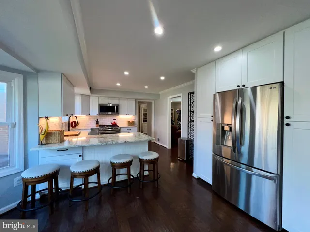 a kitchen with stainless steel appliances refrigerator dining table and chairs