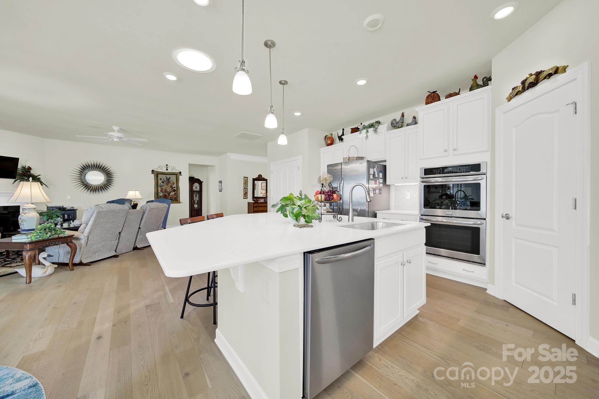 3097 Arches Bluff Circle Lancaster, SC 29720 - Photo 6 of 40 a kitchen with stainless steel appliances kitchen island granite countertop a table chairs and a refrigerator