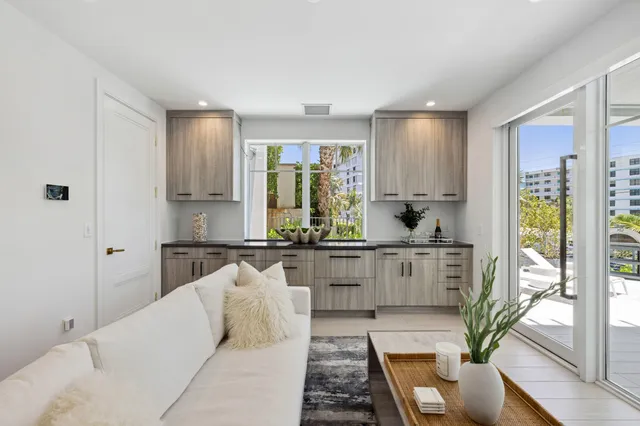 a kitchen with stainless steel appliances kitchen island granite countertop a table chairs and a refrigerator