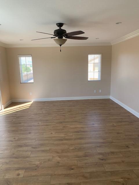 6148 Cecina Place Palmdale, CA 93552 - Photo 39 of 66 a view of a room with wooden floor ceiling fan and windows