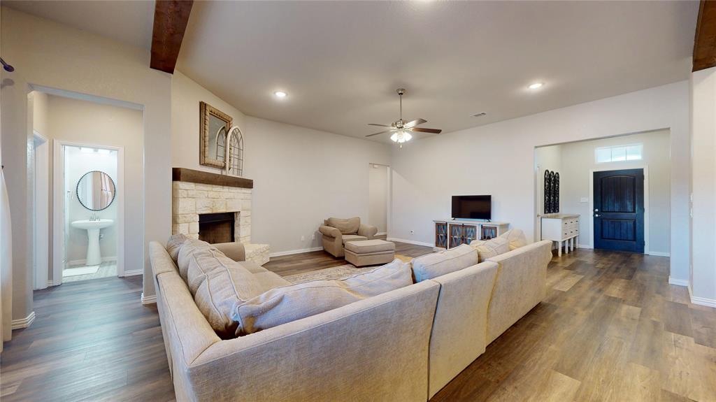 1037 Boulder Road Weatherford, TX 76085 - Photo 8 of 24 a living room with furniture a fireplace and a chandelier