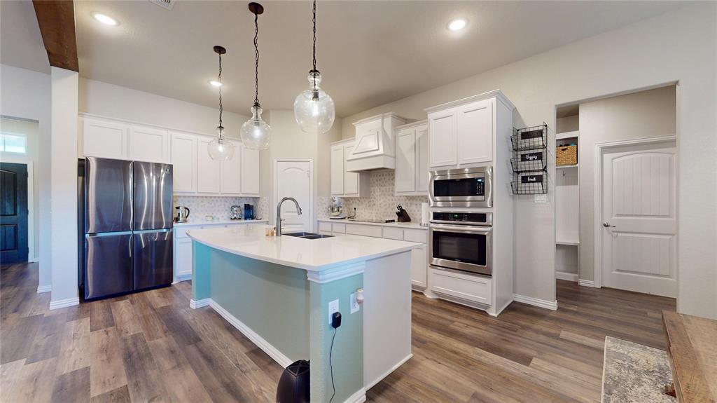 1037 Boulder Road Weatherford, TX 76085 - Photo 10 of 24 a kitchen with stainless steel appliances kitchen island a refrigerator sink and cabinets