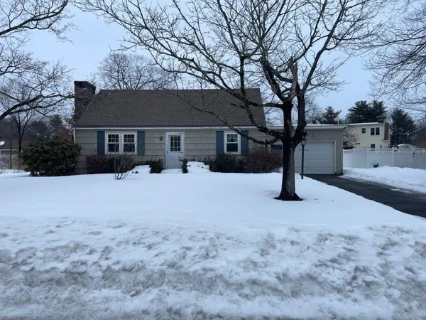 a front view of a house with a yard covered in snow