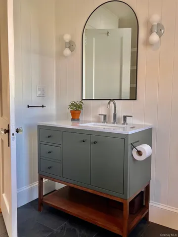 a bathroom with a sink vanity and a mirror