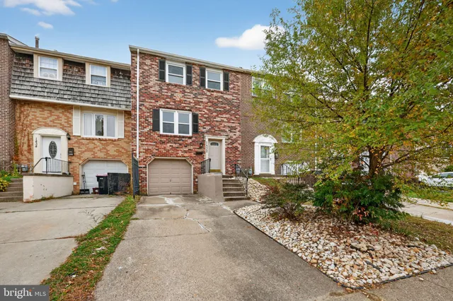 a front view of a house with yard and parking