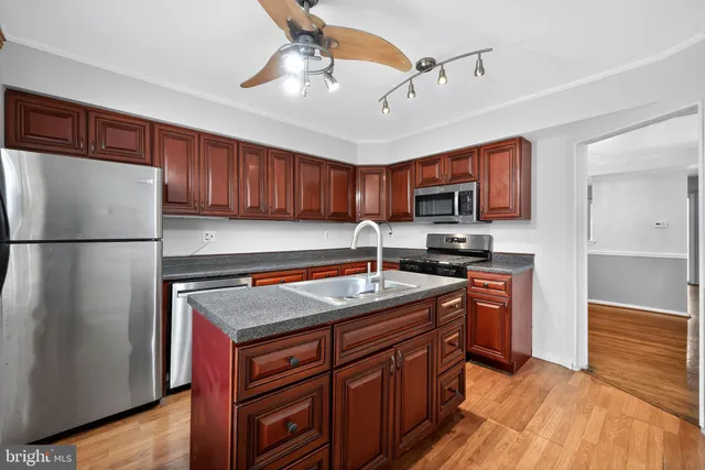 a kitchen with stainless steel appliances granite countertop a stove refrigerator sink and microwave