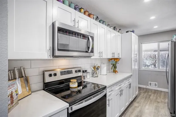 a kitchen with stainless steel appliances a stove a sink a microwave and cabinets