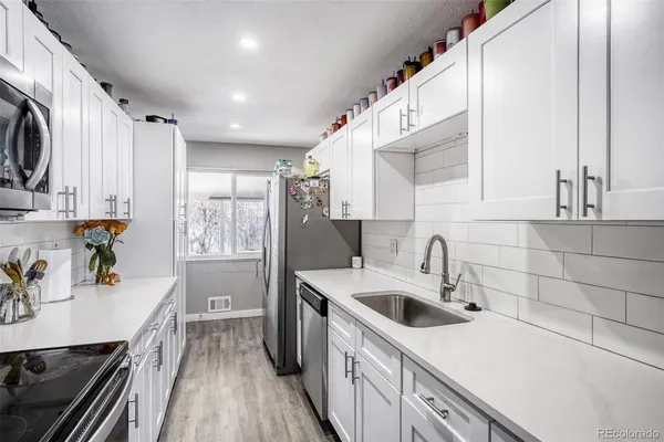 a kitchen with a sink a stove and cabinets