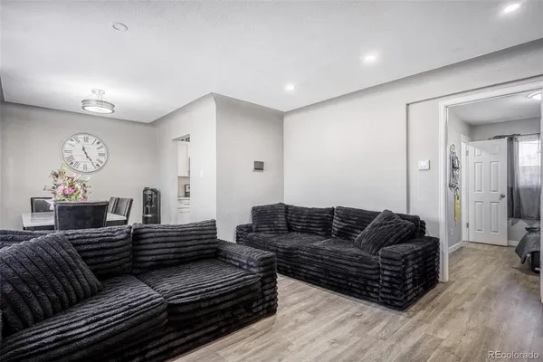 a living room with furniture a wooden floor and a chandelier