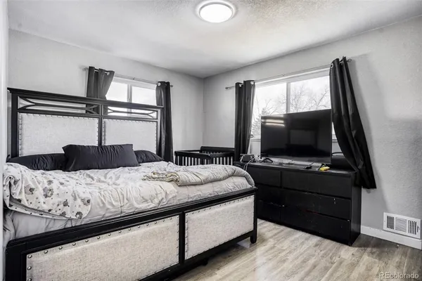 a bedroom with a bed and a flat tv screen on a dresser
