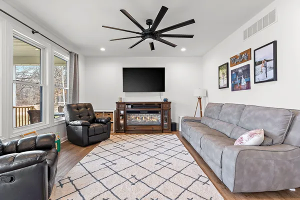 a living room with furniture and a flat screen tv with wooden floor