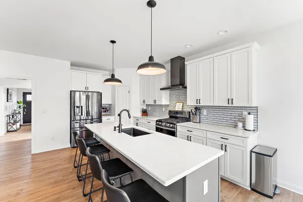 a kitchen with a table chairs and white cabinets