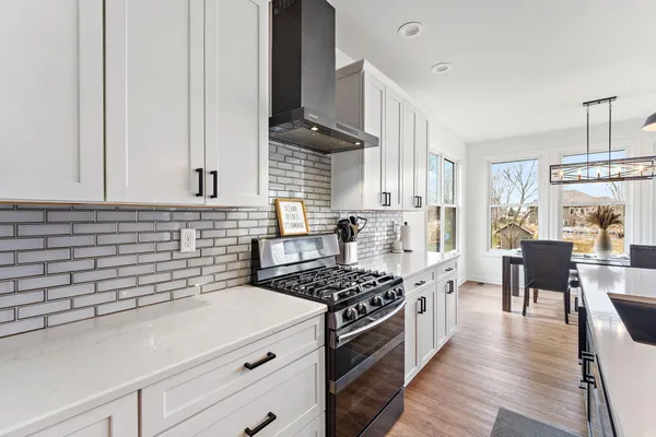 a kitchen with stainless steel appliances a stove a sink and cabinets