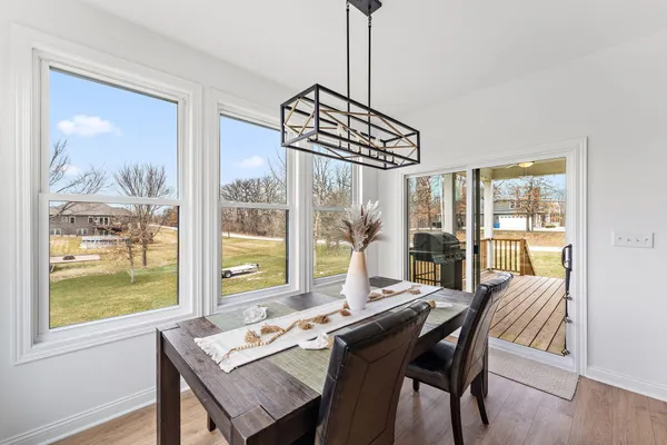 a view of a dining room with furniture large windows and wooden floor