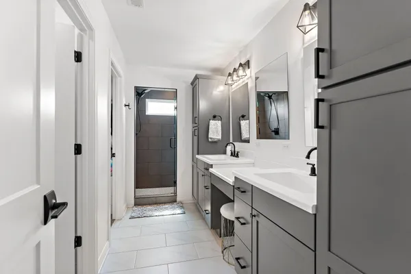 a bathroom with a sink a toilet a mirror and shower