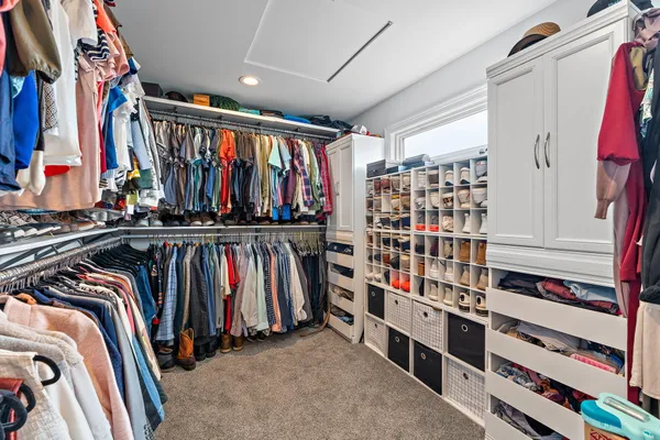 a view of walk in closet with clothes and shoes