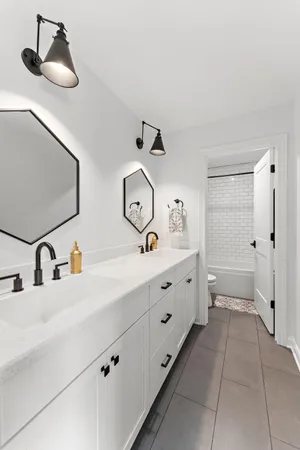 a bathroom with a double vanity sink mirror and toilet