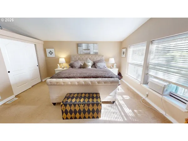 a living room with a bed furniture and a large window