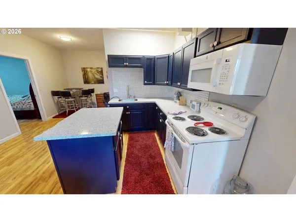 a kitchen with stainless steel appliances kitchen island sink refrigerator and stove