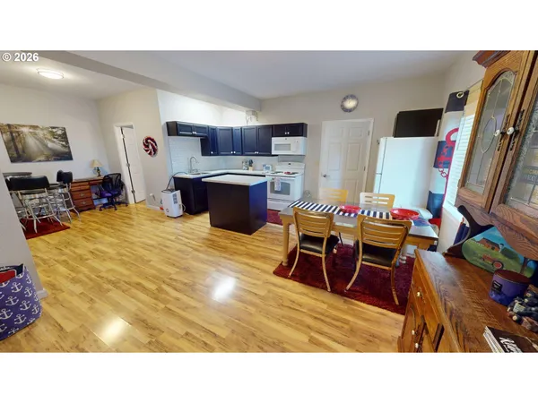 a living room with furniture a flat screen tv and kitchen view