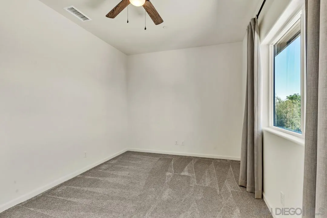 130 Scenic Drive El Cajon, CA 92021 - Photo 25 of 50 an empty room with a window and a ceiling fan