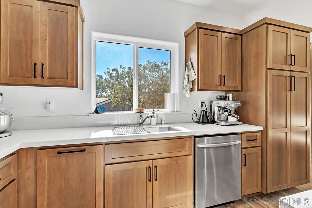 130 Scenic Drive El Cajon, CA 92021 - Photo 8 of 50 a kitchen with stainless steel appliances granite countertop a sink a refrigerator and a cabinets with wooden floor