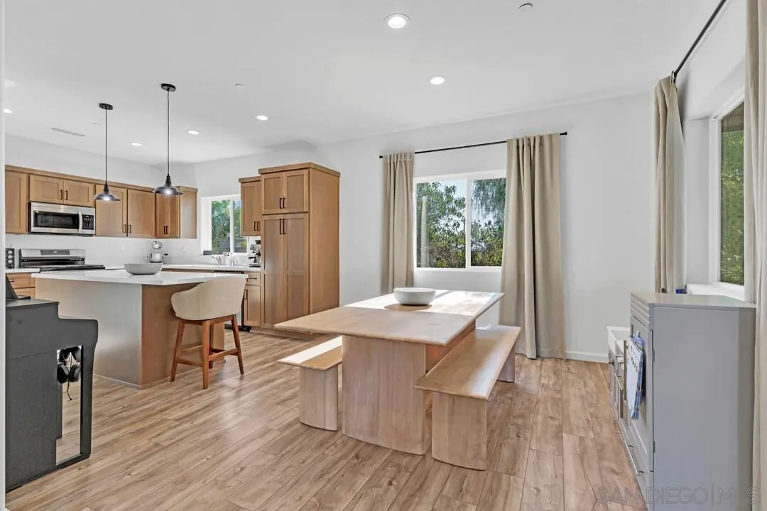 130 Scenic Drive El Cajon, CA 92021 - Photo 9 of 50 a kitchen with stainless steel appliances granite countertop a stove a refrigerator a kitchen island a dining table and chairs with wooden floor