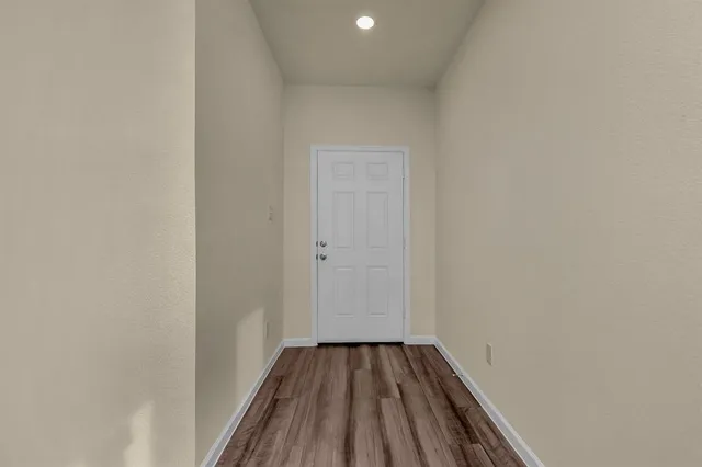 a view of a room with wooden floor and bench