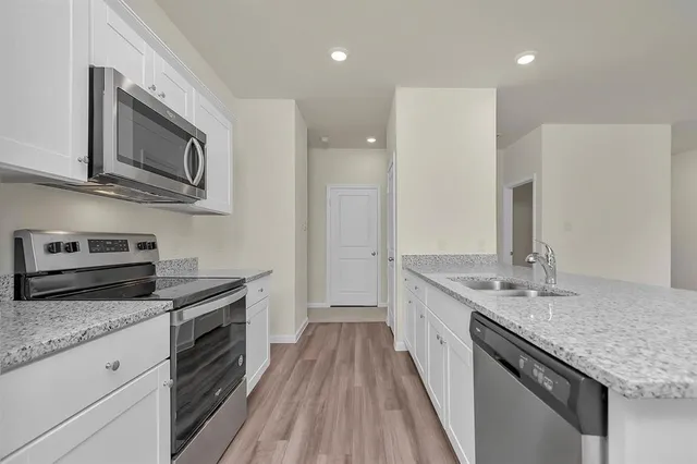 a kitchen with stainless steel appliances granite countertop a sink stove and refrigerator