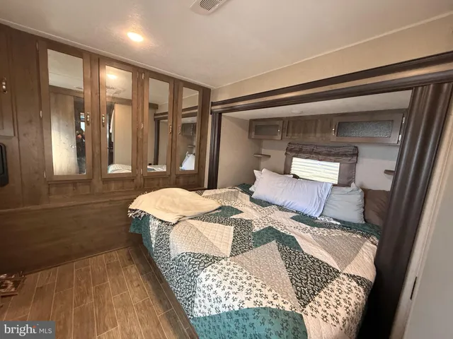 a bedroom with a large bed and a wooden floor