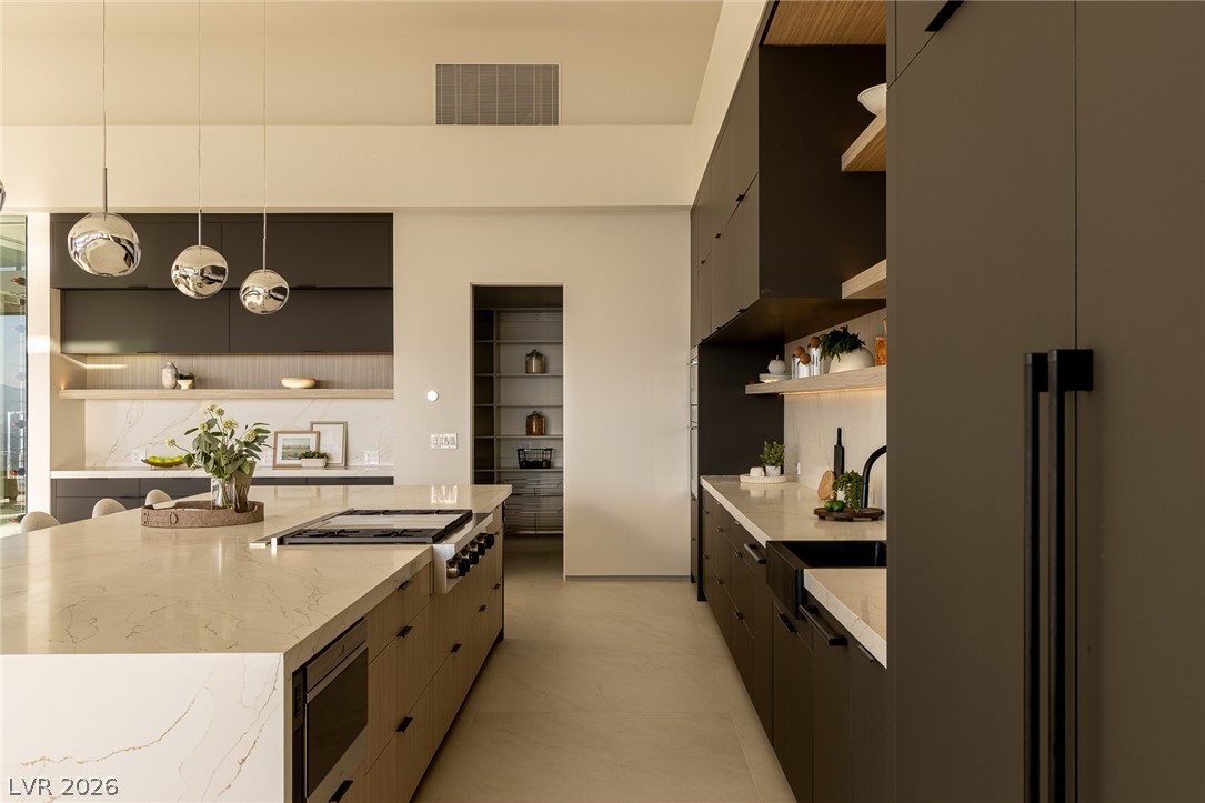 563 Grand Rim Drive Henderson, NV 89012 - Photo 15 of 70 Culinary aspirations thrive in this sleek, generously proportioned kitchen with premium fixtures and extensive storage.