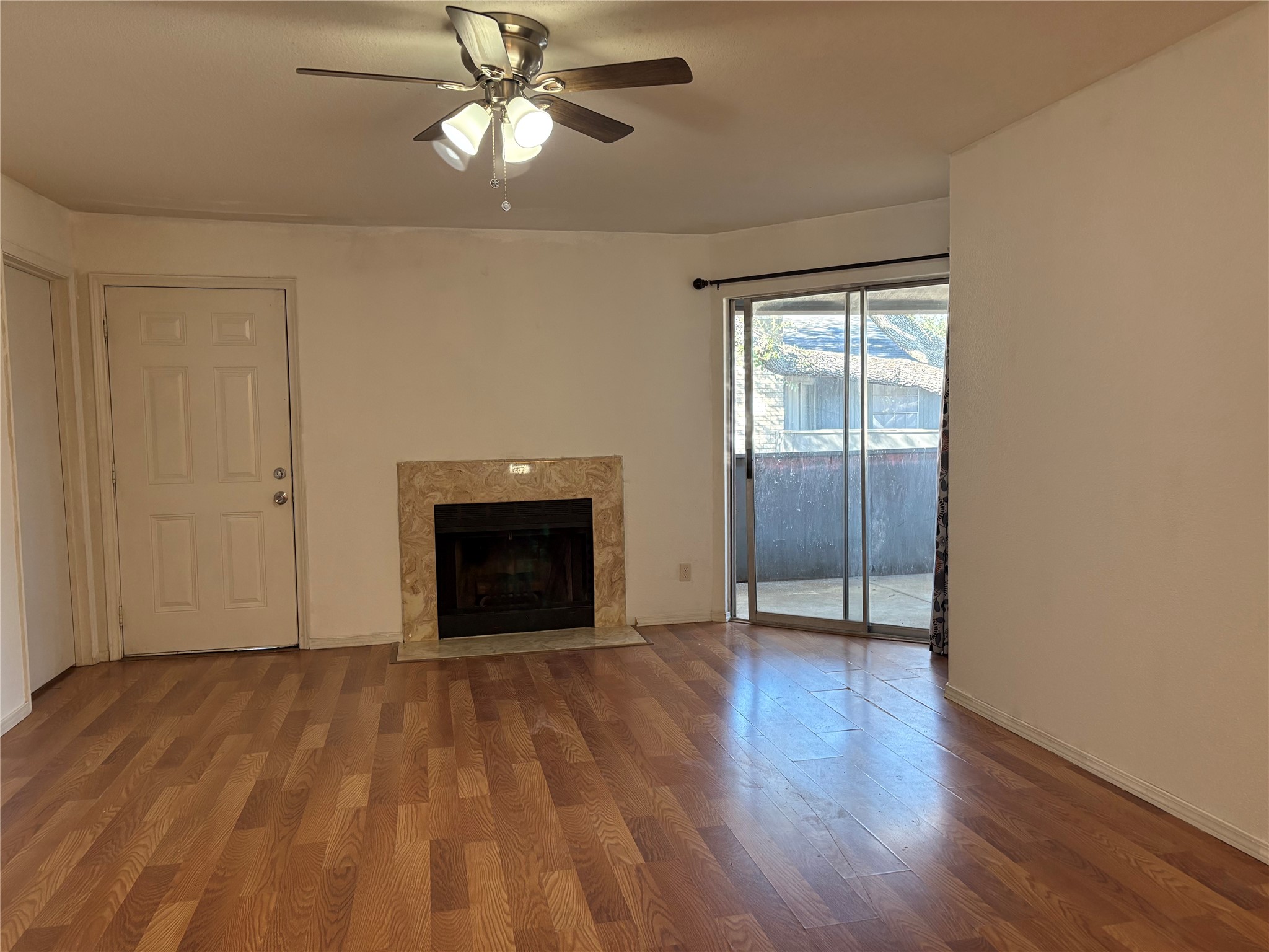 9700 Leawood Boulevard, Unit 1908 Houston, TX 77099 - Photo 4 of 7 a view of an empty room with wooden floor and a fireplace