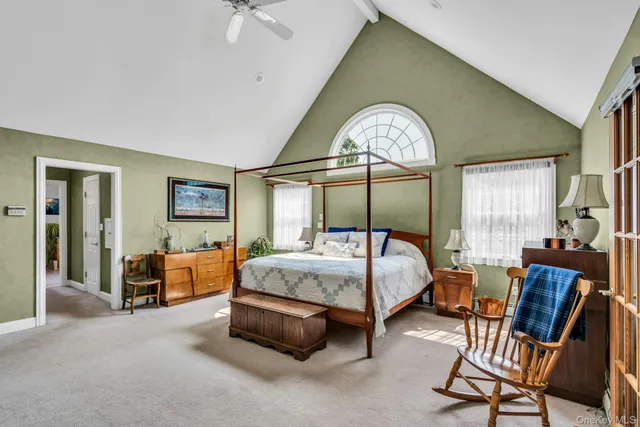 a bed sitting in a spacious bedroom next to a window
