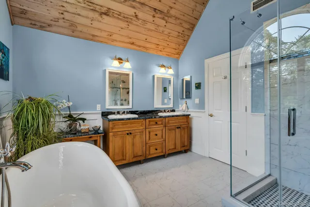 a bathroom with a double vanity sink mirror and shower