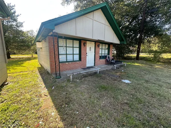 a view of a house with backyard and sitting area