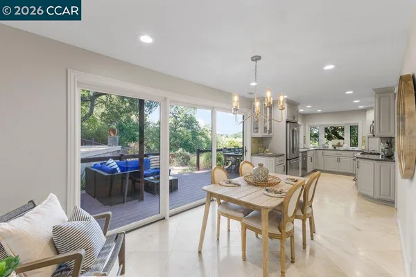 a dining room with furniture large windows and a chandelier