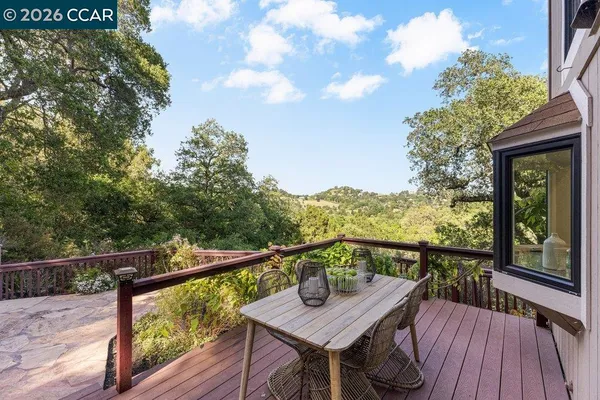 a view of a balcony with wooden floor and fence