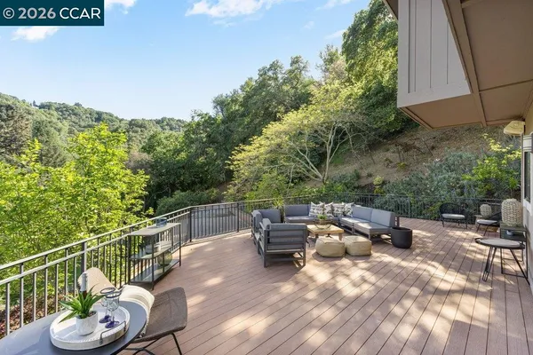 a view of a patio with a dining table and chairs with wooden floor