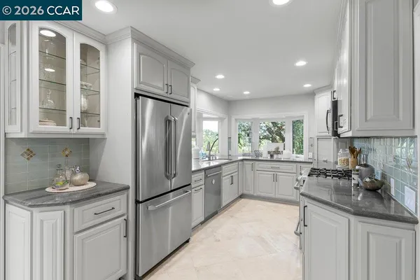 a kitchen with stainless steel appliances granite countertop a refrigerator sink and cabinets