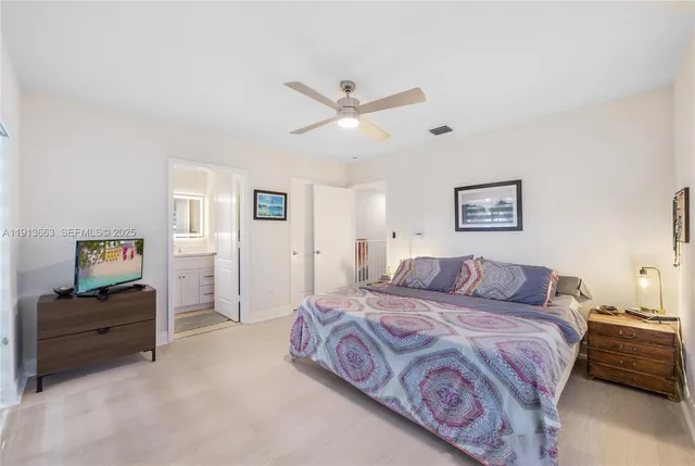 a bedroom with a large bed and a chandelier