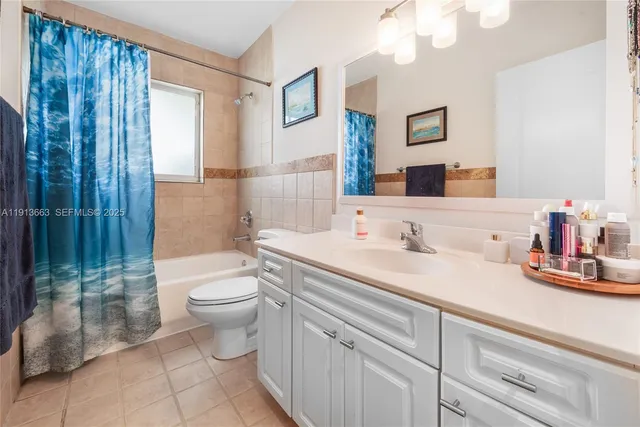 a bathroom with a granite countertop sink mirror vanity and toilet