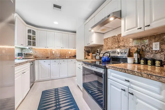 a kitchen with kitchen island granite countertop a sink and cabinets