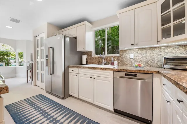 a kitchen with white cabinets and white appliances