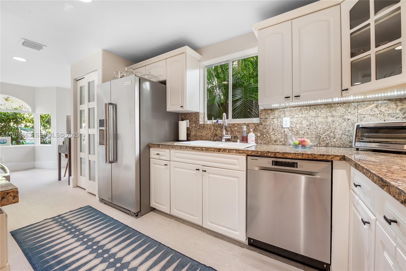 3124 Jackson Avenue, Unit 1 Miami, FL 33133 - Photo 7 of 23 a kitchen with white cabinets and white appliances