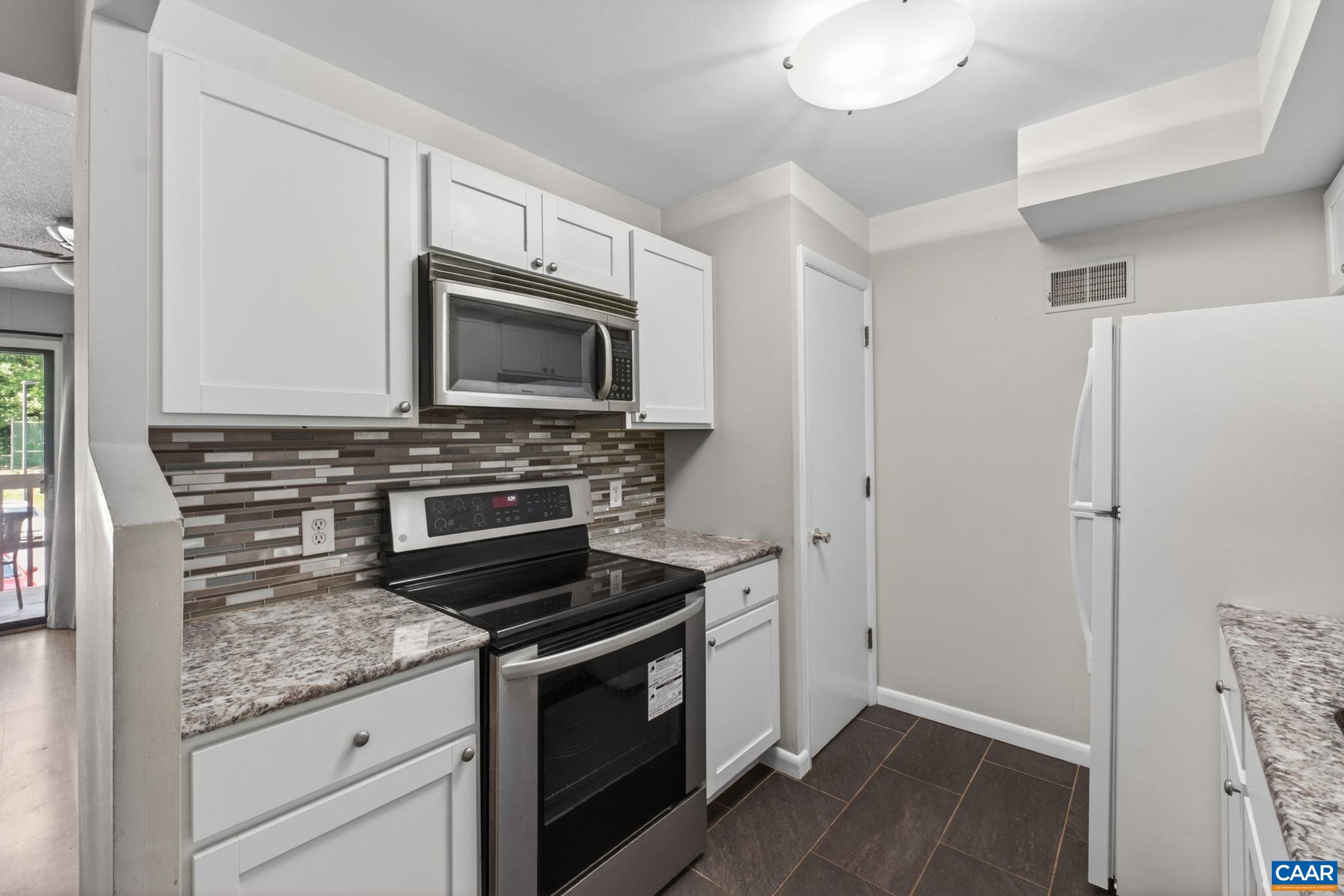 103 Turtle Creek Road, Unit 8 Charlottesville, VA 22901 - Photo 13 of 37 a kitchen with granite countertop a stove and a microwave