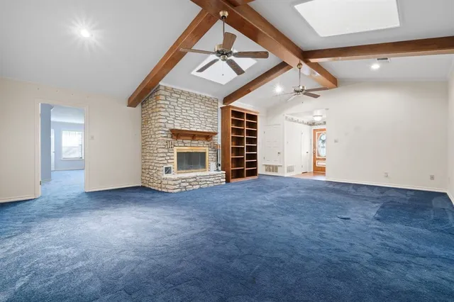 an empty room with windows and fireplace